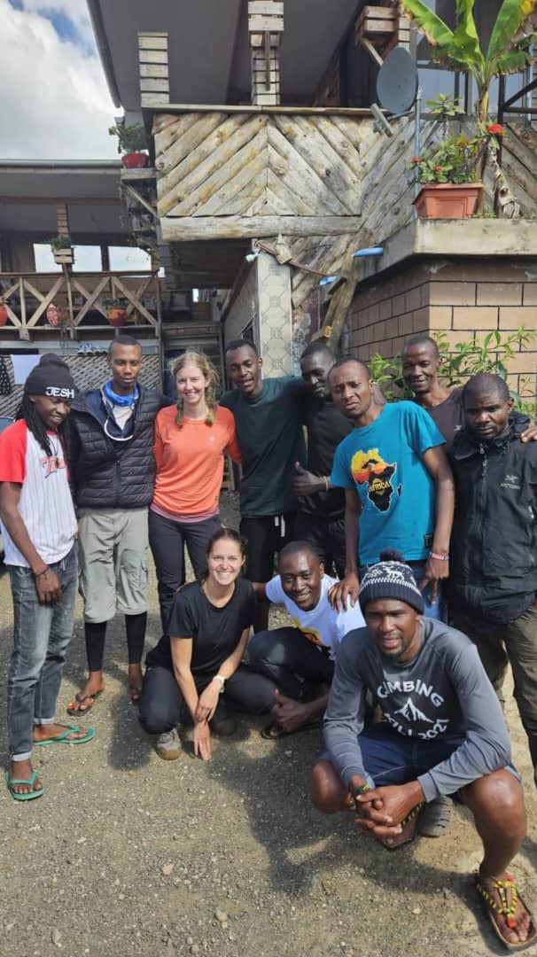 A large group of mountain crew members celebrating outside a building